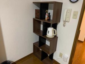 a wooden book shelf in a corner of a room at AO Dazaifu / Vacation STAY 61719 in Chikushino