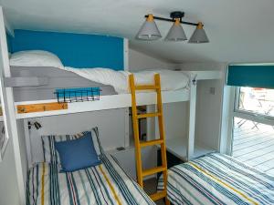 a bunk bed room with two bunk beds and a ladder at Victoria Cottage in St. Agnes