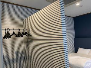 AO Dazaifu / Vacation STAY 61736 في Chikushino: غرفة نوم بحائط مخططة باللون الأزرق والأبيض