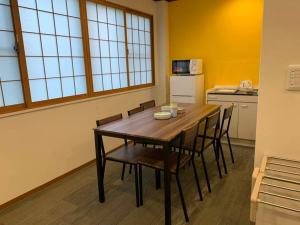 AO Dazaifu / Vacation STAY 61736 في Chikushino: مطبخ مع طاولة وكراسي خشبية في الغرفة