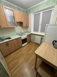 eine Küche mit Holzschränken und einem weißen Herd mit Backofen in der Unterkunft Apartament str Grenoble in Chişinău