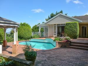 a house with a swimming pool in a yard at Athlone Lodge in Pietermaritzburg