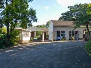 a house with a driveway in front of it at Athlone Lodge in Pietermaritzburg
