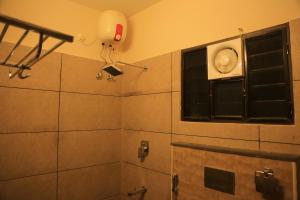 a bathroom with a shower with a window and a light at Ponni Homestay Kumbakonam in Kumbakonam