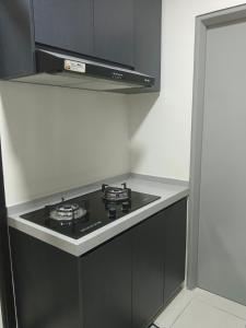 a kitchen with a black stove top oven at Homestay Melody Puncak Alam in Bandar Puncak Alam