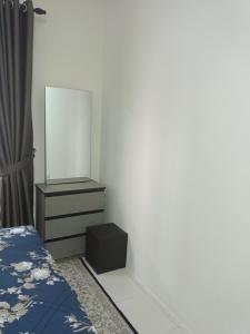 a bedroom with a bed and a dresser with a mirror at Homestay Melody Puncak Alam in Bandar Puncak Alam