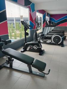 a gym with two treadmills and exercise bikes in a room at Homestay Melody Puncak Alam in Bandar Puncak Alam