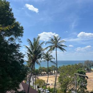 vistas a una playa con palmeras y al océano en Kata Villa Merit Hill Bungalows en Ka Rorn