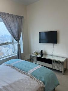 una camera con TV a schermo piatto e letto di 22 R2 Luxury Room in a 4-bedroom apartment with a private washroom outside the room ### 22 R2 غرفة فاخرة في شقة 4 غرف نوم مع حمام خاص خارج الغرفة ### ad Ajman