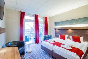 a hotel room with a large bed and a table and chairs at Seehotel Brandenburg an der Havel in Brielow