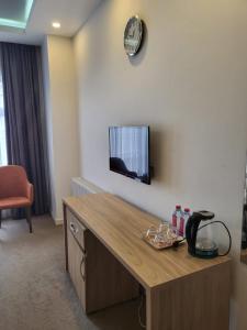 Noor hotel في باكو: غرفة مع مكتب وتلفزيون على الحائط