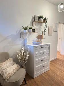 a white dresser and a chair in a room at Apartma Naty in Ljubljana