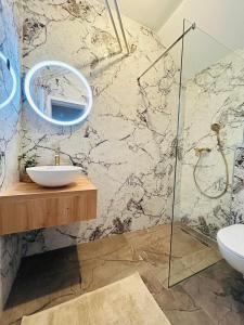 W łazience znajduje się umywalka i lustro. w obiekcie Apartma Naty w Lublanie