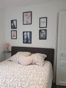 - une chambre dotée d'un lit avec des photos sur le mur dans l'établissement Bel appartement avec patio, à Villejuif