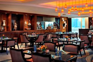 une salle à manger avec des tables et des chaises dans l'établissement Courtyard By Marriott Kuwait City, à Koweït