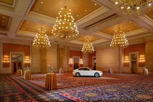 a white car parked in a lobby with chandeliers at Courtyard By Marriott Kuwait City in Kuwait
