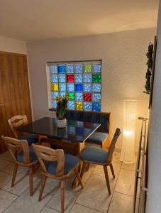 a dining room with a table and chairs and a stained glass window at Pension FAULPELZ - Doppelzimmer Standard in Niederorschel