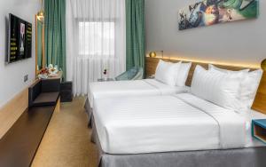 麥加的住宿－M Hotel Al Dana Makkah by Millennium，酒店客房设有一张白色大床和一个窗户。