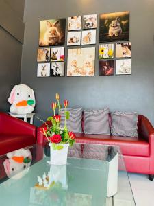 a living room with a red couch and a glass table at Rabbitel Phuket in Phuket Town