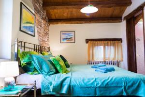 a bedroom with a bed with blue and green pillows at Rural Pension Istra Partner in Barban