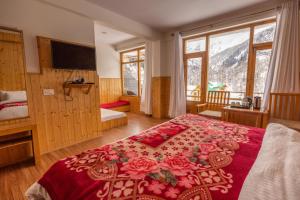 um quarto com uma cama grande e um cobertor vermelho em Adventure Valley em Manali