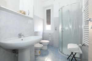 a white bathroom with a sink and a toilet at SAN MARTINO HOUSE in Genova