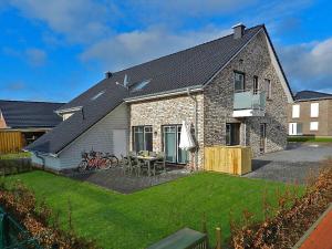 a brick house with a table and chairs in a yard at Holiday home sea breeze in Burhave