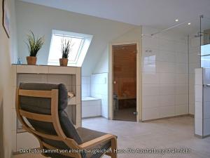 a living room with a chair and a bathroom at Holiday home sea breeze in Burhave +29 photos