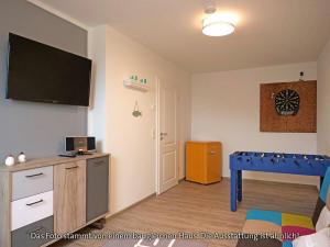 a living room with a table and a flat screen tv at Holiday home sea breeze in Burhave
