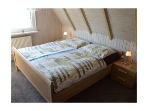 a large bed in a bedroom with two night stands at Holiday home Achtern Diek 29 a in Otterndorf