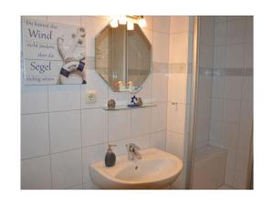a bathroom with a sink and a shower at Holiday home Achtern Diek 29 a in Otterndorf +14 photos