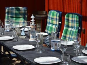 a table with chairs and plates and wine glasses at Holiday home Achtern Diek 29 a in Otterndorf