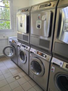un montón de lavadoras en una lavandería en Studio au calme dans résidence Gauguin pour location courte durée et étudiants en Gières