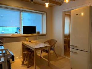 eine Küche mit einem Holztisch und einem TV in der Unterkunft liilliil Residence Seoul in Seoul