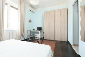 a bedroom with a white bed and a desk at Affittacamere "SAN MARTINO ROOMS" in Genova