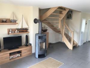 a living room with a wood stove and a staircase at Holiday home Lilly in Staberdorf