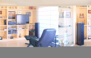 a living room with a chair and a television at Stunning Apartment In Tossa De Mar With 3 Bedrooms And Wifi in Tossa de Mar