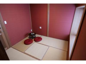 una piccola camera con due tappetini rossi sul pavimento di YAKATA - Vacation STAY 58651v a Yuzawa