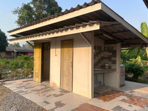 a small house with a roof on a patio at NADOHN Camper in Ban Nam Lai Ta Tum