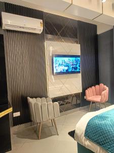 um quarto com duas cadeiras e uma televisão na parede em Lieu D Amour em Srinagar