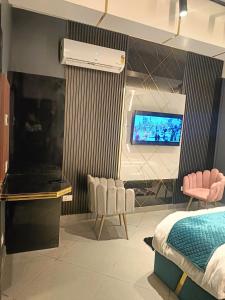 Schlafzimmer mit einem TV, einem Bett und einem Bett in der Unterkunft Lieu D Amour in Srinagar