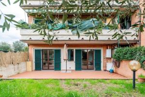 a house with green doors and a patio at Appartamento 70mq con giardino e parcheggio in Florence