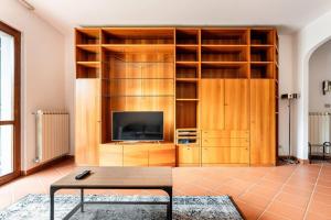a living room with a tv and a book shelf at Appartamento 70mq con giardino e parcheggio in Florence