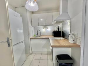 a small kitchen with white cabinets and a sink at Appartement T2 centre ville, balcon in Bonneville +5 photos