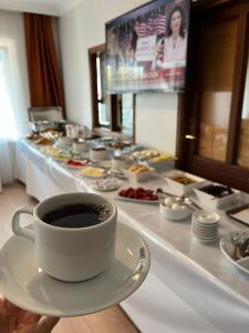 a cup of coffee on a plate next to a buffet of food at GRAND KENT OTEL in Bilecik