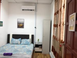 een slaapkamer met een bed, een tafel en een deur bij Alia Express CZ Hotel in Pasir Puteh