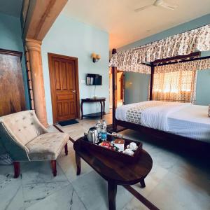 a bedroom with a bed and a table and a chair at RAGHVENDRA HERITAGE in Jodhpur