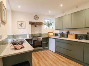 a kitchen with green cabinets and a counter top at Knoll Cottage in Bakewell