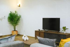 een woonkamer met een flatscreen-tv op een kast bij Spacious 3 Bedroom Apartment in Tema, Accra, Ghana in Tema