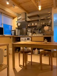 a kitchen with a wooden table with stools in it at liilliil Residence Seoul in Seoul